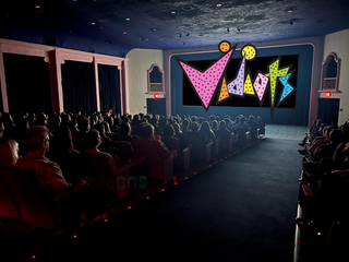 Image of Vidiots theater, full audience with Vidiots logo on screen.